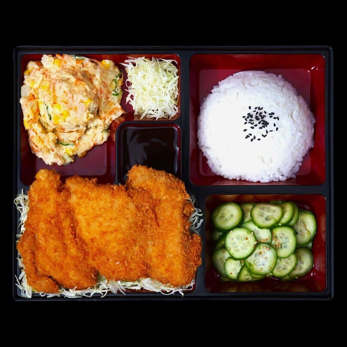 Chicken katsu bento box with rice, cabbage, potato salad and cucumber salad