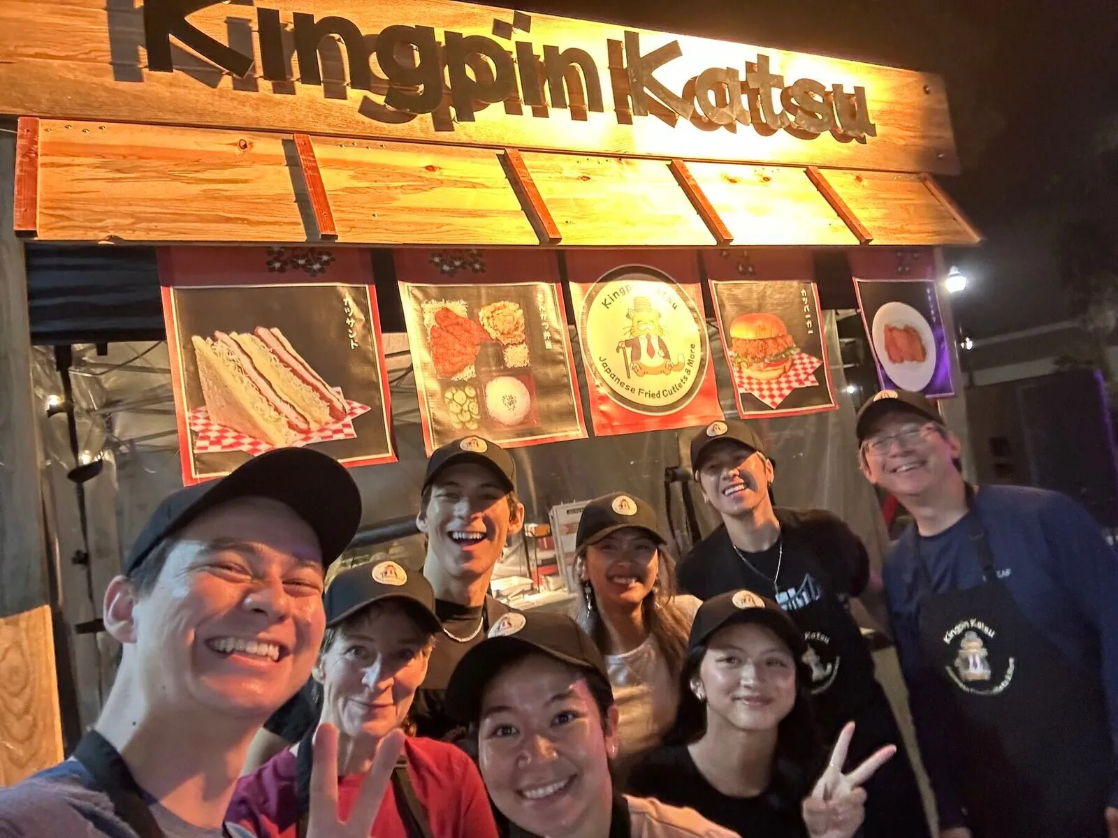 The Kingpin Katsu family and crew smiling at the booth